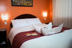 a bed with two plates of food on it at Hotel Margarita in Puno +83 photos