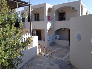 a building with white walls and a stairway leading to it at Chios Panorama in Karfas