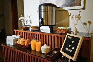 a counter with a coffee maker and bread and drinks at Hotel Margarita in Puno