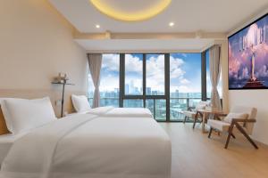 a bedroom with a large white bed and a large window at 妮可酒店解放碑店 in Chongqing