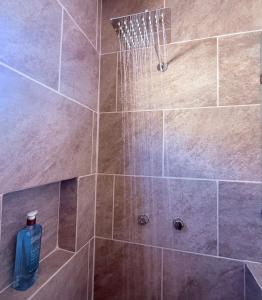 a shower with a blue bottle of water at Estancia Moderna y cerca del Malecon de La Paz in La Paz
