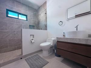 a bathroom with a toilet and a sink and a mirror at Estancia Moderna y cerca del Malecon de La Paz in La Paz