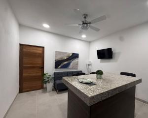 a living room with a kitchen with a ceiling fan at Estancia Moderna y cerca del Malecon de La Paz in La Paz