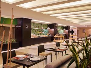 a restaurant with tables and chairs and a store at ibis Amman in Amman