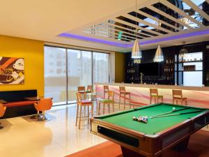 a pool table in a room with a bar at ibis Amman in Amman