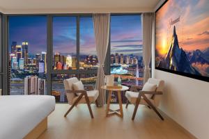 a bedroom with a large window with a view of a city at 妮可酒店解放碑店 in Chongqing