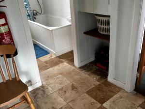 a bathroom with a tub and a tiled floor at Strathnoon in Inverness +9 photos