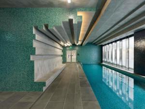 a swimming pool in a building with green walls at The Sebel Residences Melbourne Docklands Serviced Apartments in Melbourne