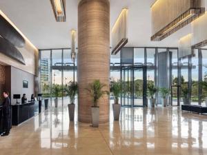 a lobby with potted plants in a building at Novotel Citygate Hong Kong in Hong Kong +79 photos