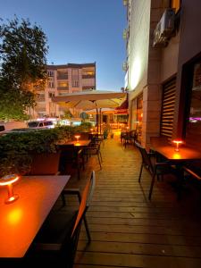 an outdoor patio with tables and chairs and lights at Hotel Güleryüz 2 in Antalya