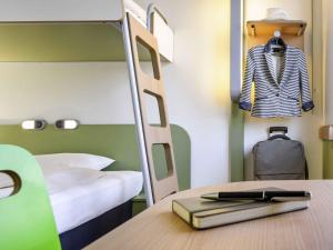 a bedroom with a bunk bed and a desk with a book at Ibis Budget Málaga Centro in Málaga +57 photos