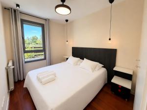 a bedroom with a large white bed with a window at Green Valley Las Margas Golf in Latas