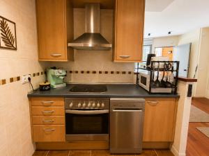 a kitchen with wooden cabinets and a stove top oven at Green Valley Las Margas Golf in Latas +24 photos