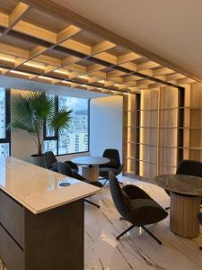 an office with tables and chairs and a palm tree at Suite de Lujo la Carolina in Quito +44 photos