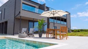 a table and chairs with an umbrella next to a pool at CIN Garden Terrace in Futtsu