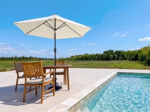 a table with an umbrella and chairs next to a swimming pool at CIN Garden Terrace in Futtsu
