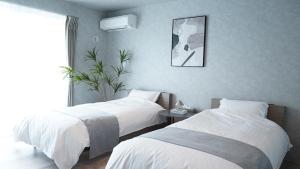 a bedroom with two beds and a potted plant at CIN Garden Terrace in Futtsu +132 photos