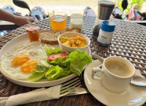 a table with a plate of food and a cup of coffee at BlueHome Vientiane in Vientiane