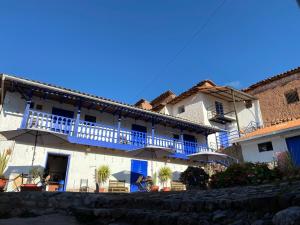 a large white building with a balcony with umbrellas at Auquis Hostel in Cusco