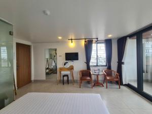 a room with a table and chairs and a television at SUN HOTEL in Hue