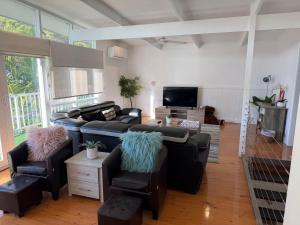 a living room with a couch and chairs and a tv at The Resort at 222 in Cowes