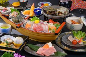 a table topped with plates of sushi and food at Toba ryokan michishio in Toba