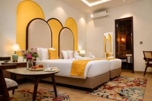 a bedroom with a large bed and a table at Kadamb Kuteer Hotel and Resort in Chhatikara +103 photos