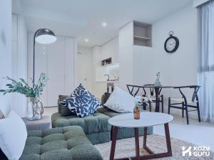 a living room with a couch and a table at KozyGuru | Box Hill | Chic & Close to It All in Box Hill
