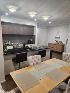 a kitchen with a dining table and a kitchen with a counter at 11 Lomond street in Beveridge