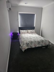 a bedroom with a bed with a floral bedspread at 11 Lomond street in Beveridge
