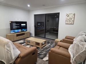 a living room with a couch and a tv at 11 Lomond street in Beveridge