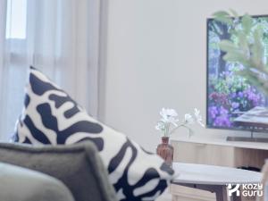 a living room with a couch and a vase of flowers on a table at KozyGuru | Box Hill | Chic & Close to It All in Box Hill +9 photos