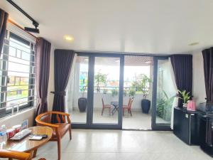 a living room with a table and chairs and sliding glass doors at SUN HOTEL in Hue