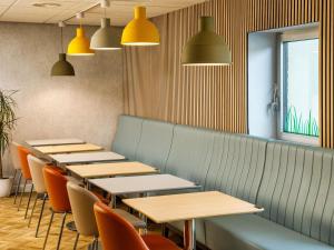 a row of tables and chairs in a restaurant at ibis budget Leicester in Leicester