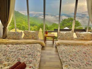 two beds in a room with a view of a mountain at Cuc ku homestay in Ấp Ða Lợi +13 photos