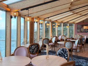 a restaurant with tables and chairs and the ocean at Mercure Granville Le Grand Large in Granville