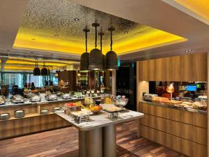 a buffet line in a restaurant with food on display at Naumi Hotel Singapore in Singapore