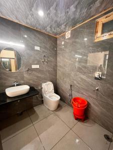a bathroom with a toilet and a sink and a mirror at Nomad Bed & Breakfast in Manāli +25 photos