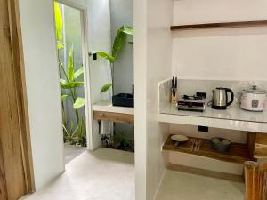 two images of a kitchen with a counter and a kitchen at Villa Gumamela Siargao in Catangnan