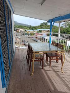 a glass table and two chairs on a balcony at Grace Homestay in Somosomo
