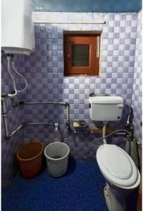 a bathroom with a toilet and a bucket in it at A Sappers Dream House Markoot Gurez in Gurais