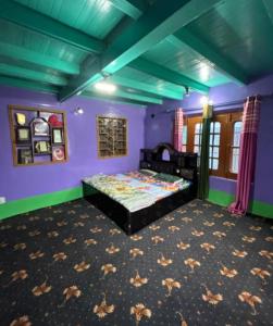 a bedroom with a bed in a purple room at A Sappers Dream House Markoot Gurez in Gurais