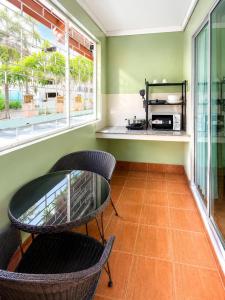 a dining room with a table and chairs and windows at J STAR in Jomtien Beach
