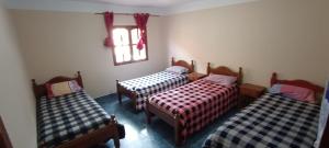 a room with three beds and a window at El Refugio de Anita in Iruya
