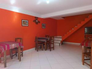 a room with red walls and tables and a staircase at El Refugio de Anita in Iruya