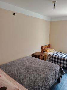 a bedroom with two beds and a dresser in it at El Refugio de Anita in Iruya