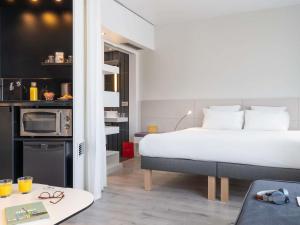 a hotel room with a bed and a kitchen at Novotel Suites Malaga Centro in Málaga