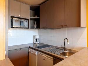 a kitchen with a sink and a microwave at Aparthotel Adagio Paris XV in Paris
