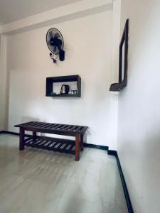 a room with a bench and a fan on a wall at Samadhi Nature Resort in Ella