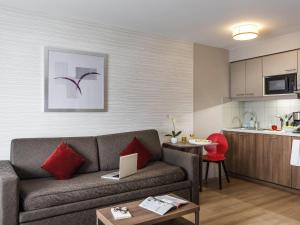 ein Wohnzimmer mit Sofa und eine Küche in der Unterkunft Aparthotel Adagio Paris Bercy Village in Paris + 105 Fotos